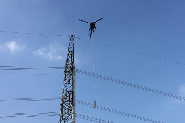南方电网成功进行运行线路直升机带电作业 系国内首次